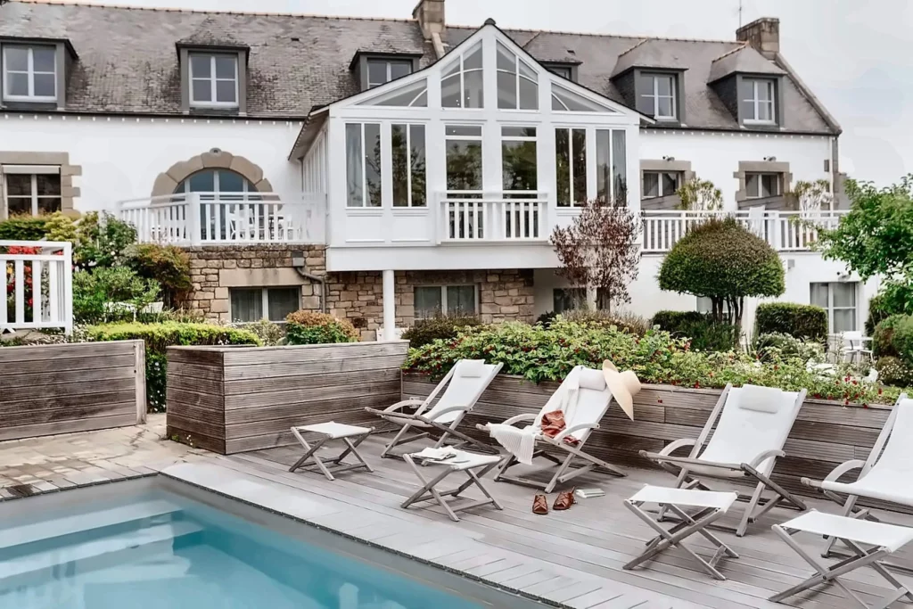 Piscine et terrasse en bois avec transats devant un Hôtel Golfe Morbihan, Le Lodge Kerisper